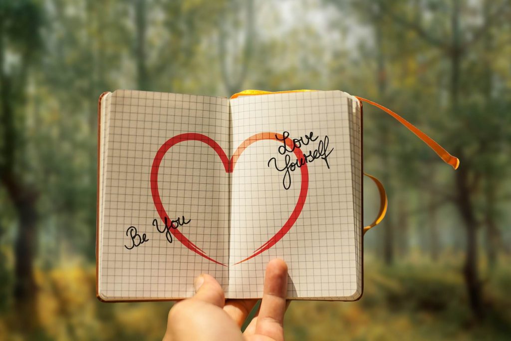 quaderno che mostra un cuore con su scritto ama te stesso