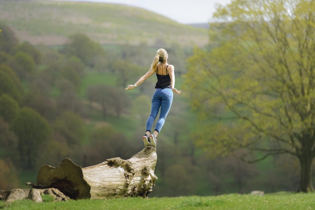 ragazza in equilibrio su un tronco